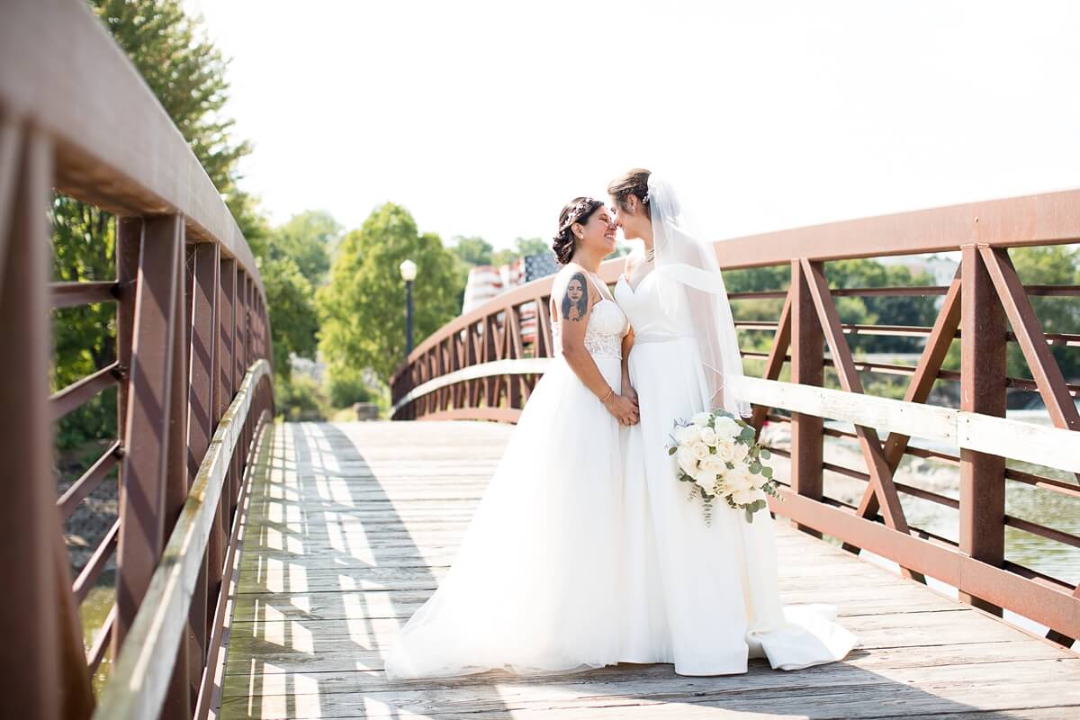 Brides standing on bridge and looking at each other