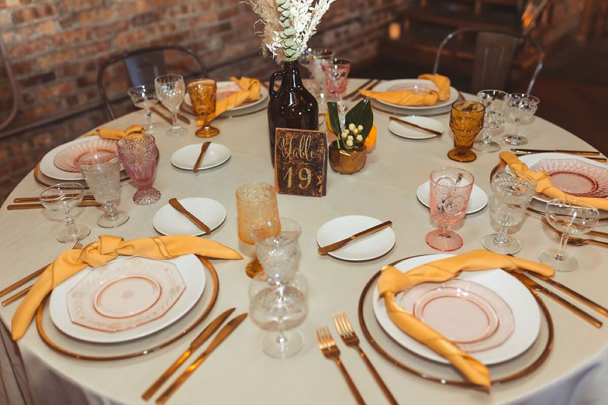White plates with yellow napkins and gold flatware at styled shoot