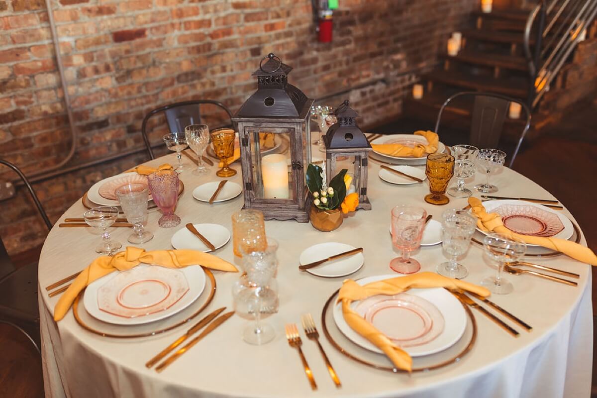 White plates with yellow napkins and gold flatware at boho styled shoot