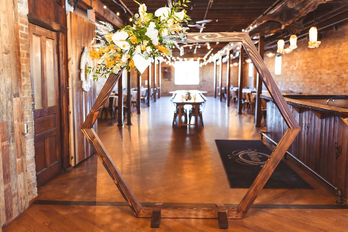Yellow and white flowers on hexagon arch at loft wedding venue Chicago