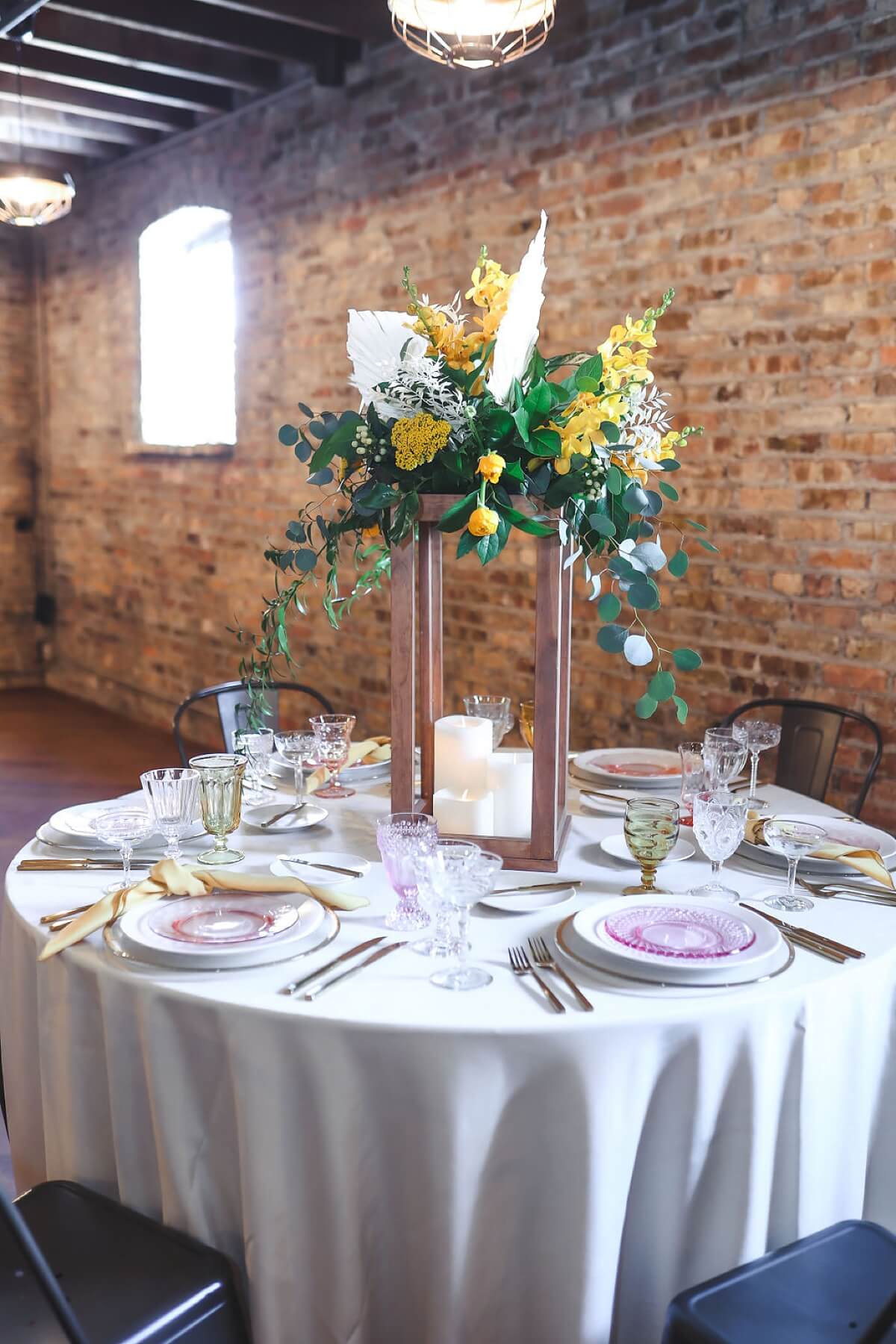 Tall wooden centerpiece with yellow and white flowers on top