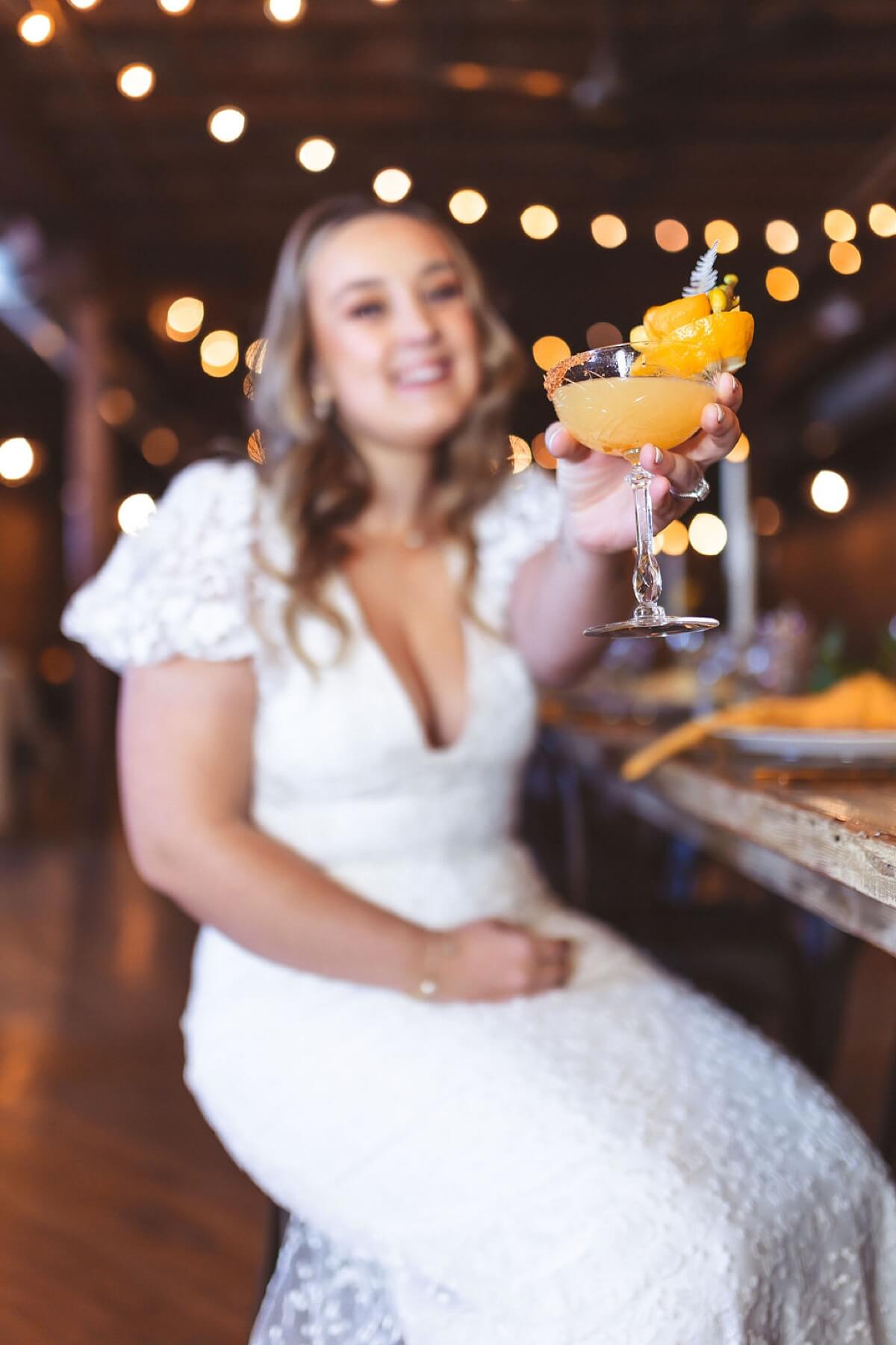 Bride toasting with yellow cocktail