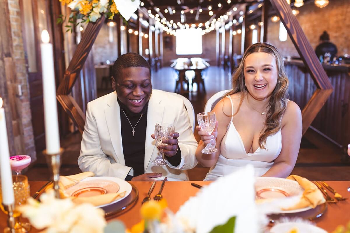 Couple sitting at sweetheart table and laughing