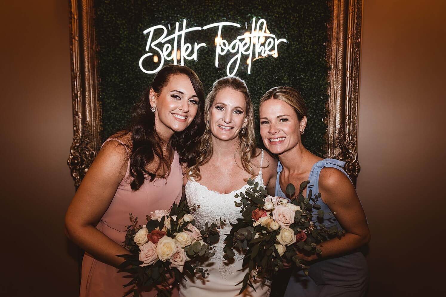 Bride with bridesmaids in front of Better Together sign at The Haight, a winter wedding venue