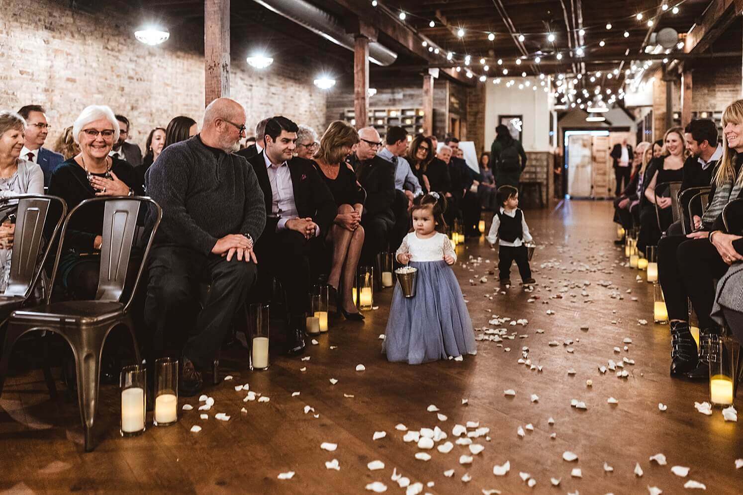Ring bearer and flower girl walking down the aisle at The Haight, a winter wedding venue