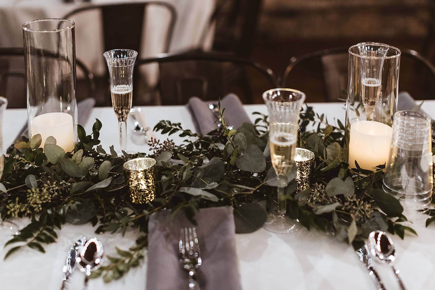 Greenery and candles reception decor at winter wedding venue