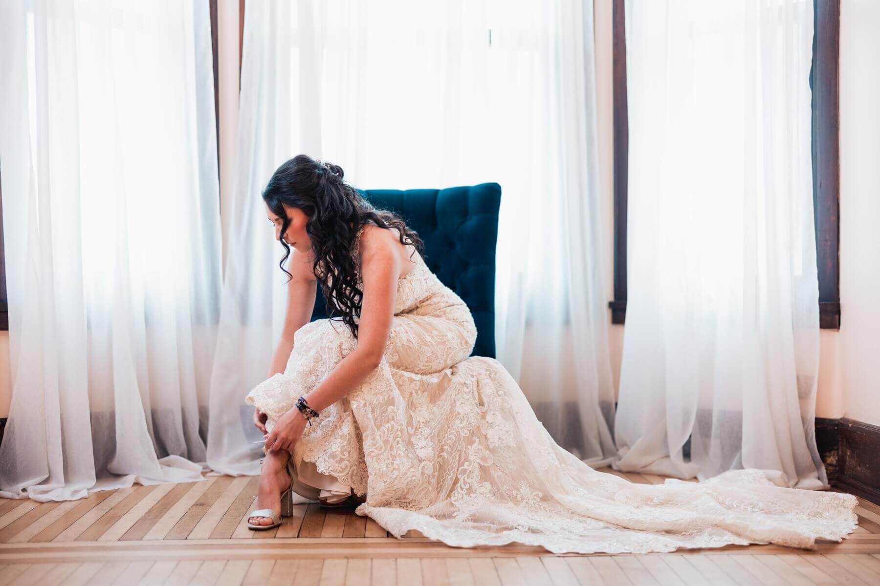 Bride putting on shoe at wedding venue in Illinois