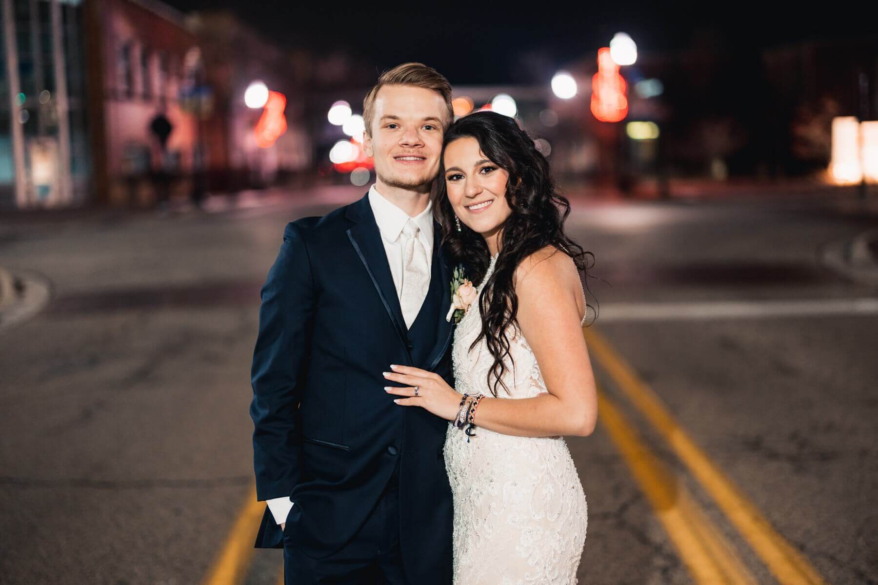 Bride and groom standing in road for night picture at wedding venue in Illinois