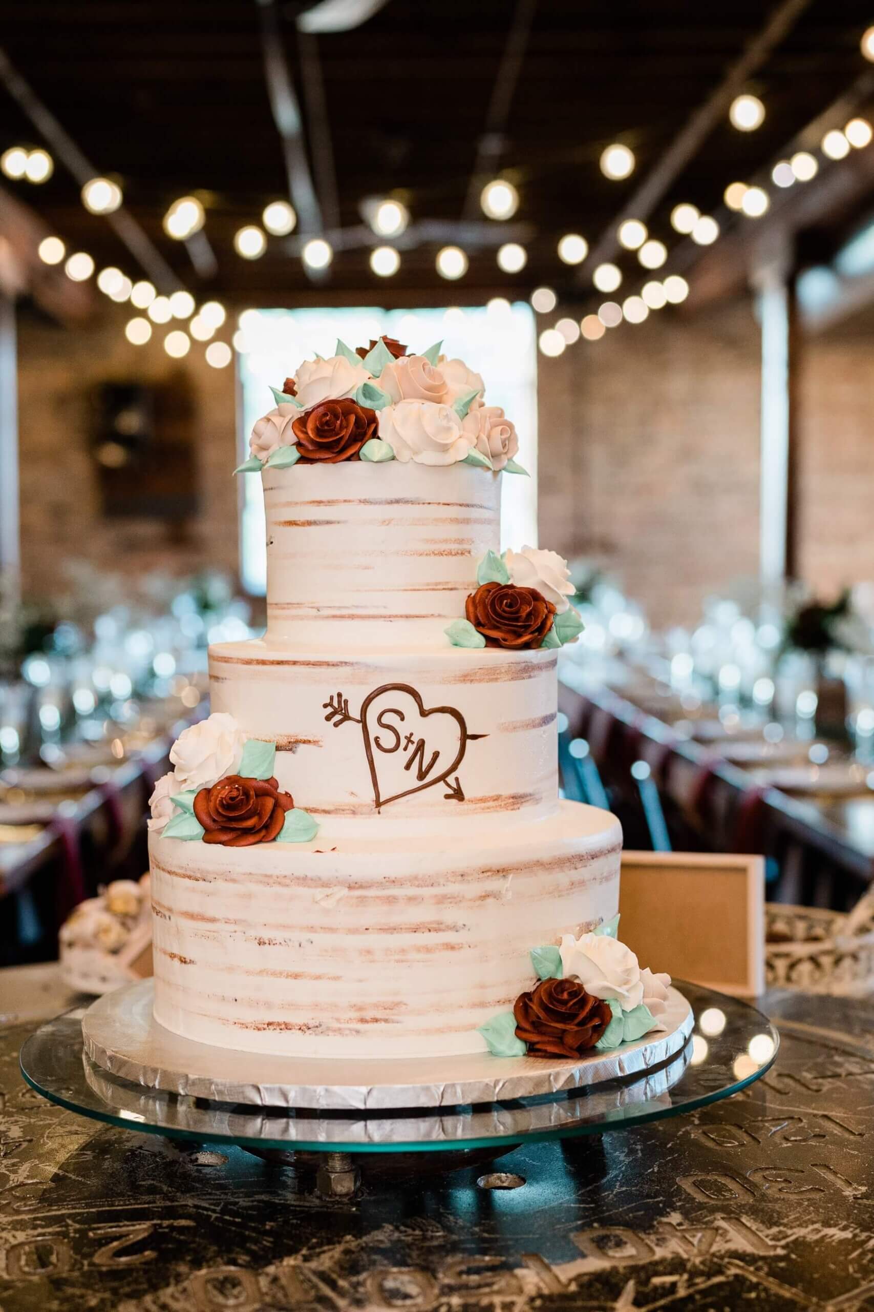 Three tier wedding cake designed like a tree with couple's initials carved in it