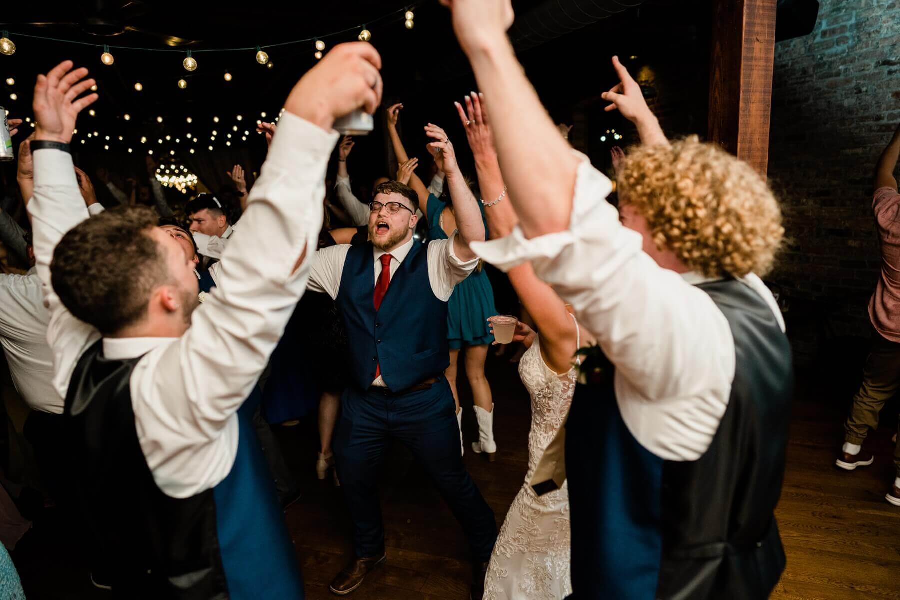 Groom dancing with groomsmen at wedding reception at The Haight