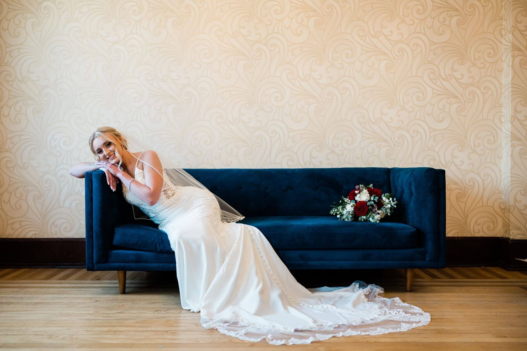 Bride lounging on blue couch at The Haight