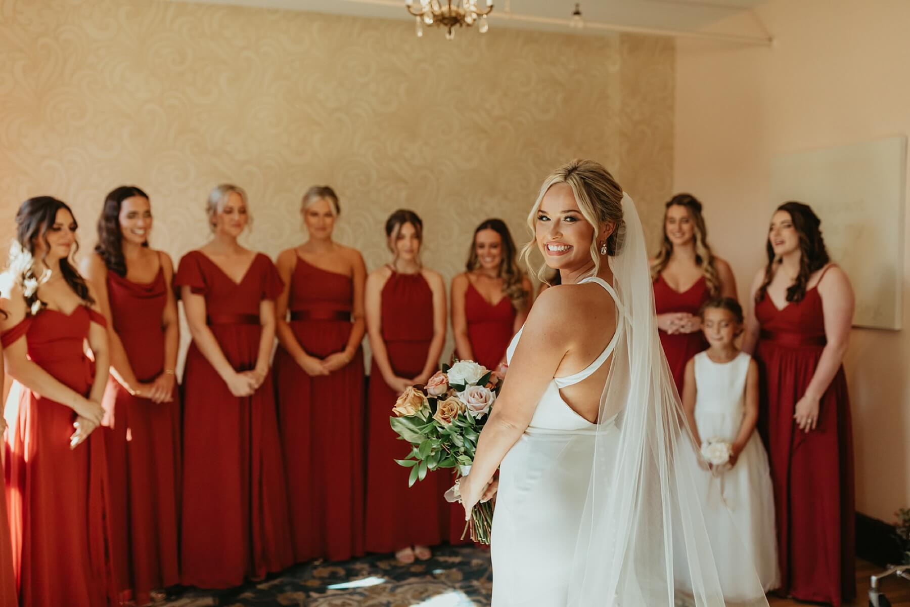 Bride standing in front of bridesmaids with their eyes closed