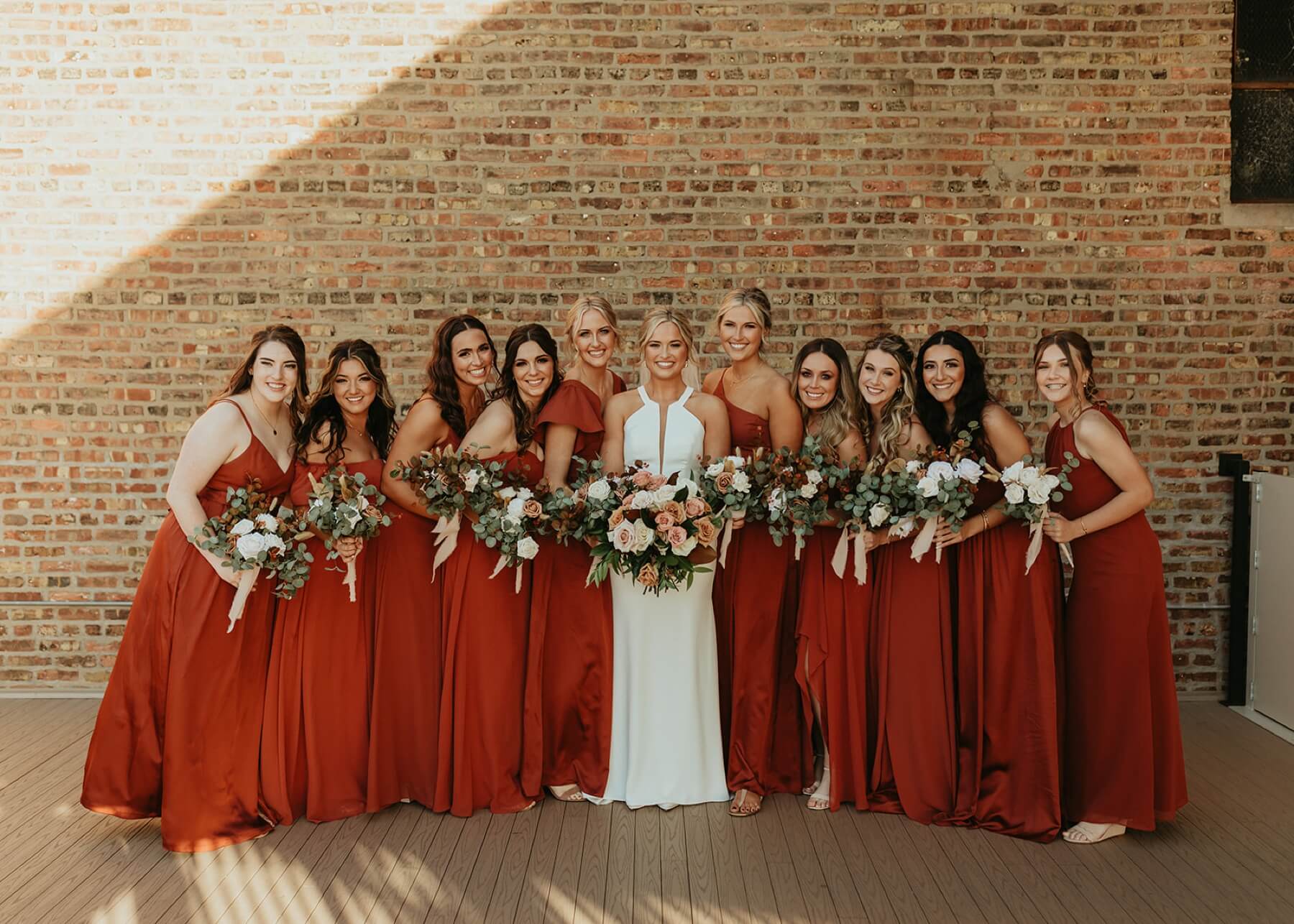Bridesmaids wearing burnt orange dresses at fall wedding