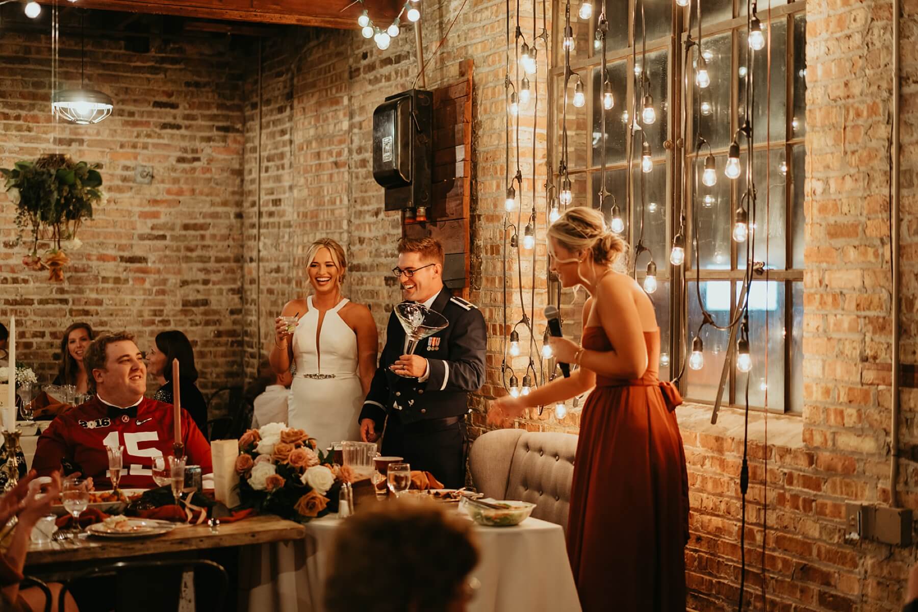 Bride and groom laughing during maid of honor toast