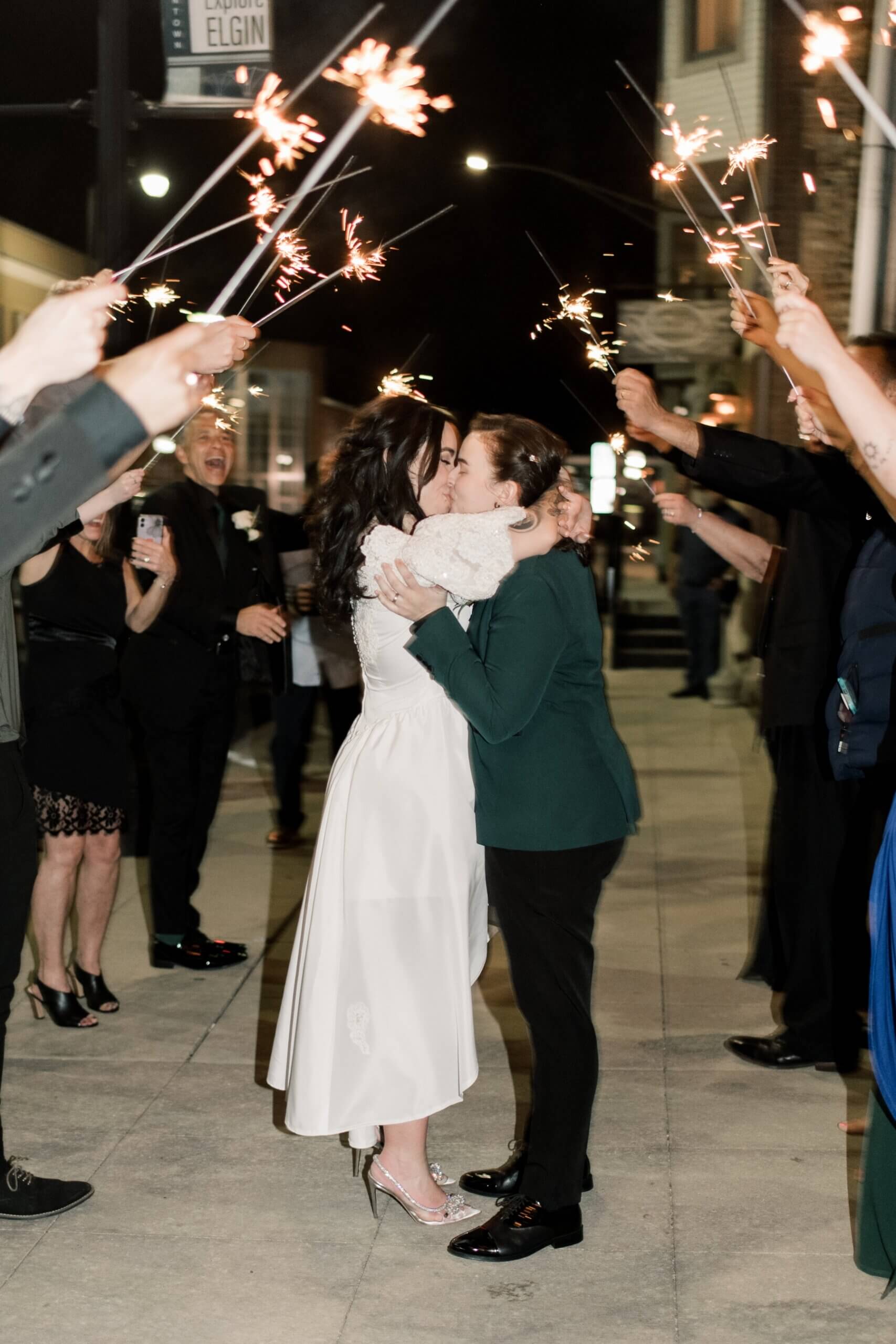 Couple kissing under sparklers during exit