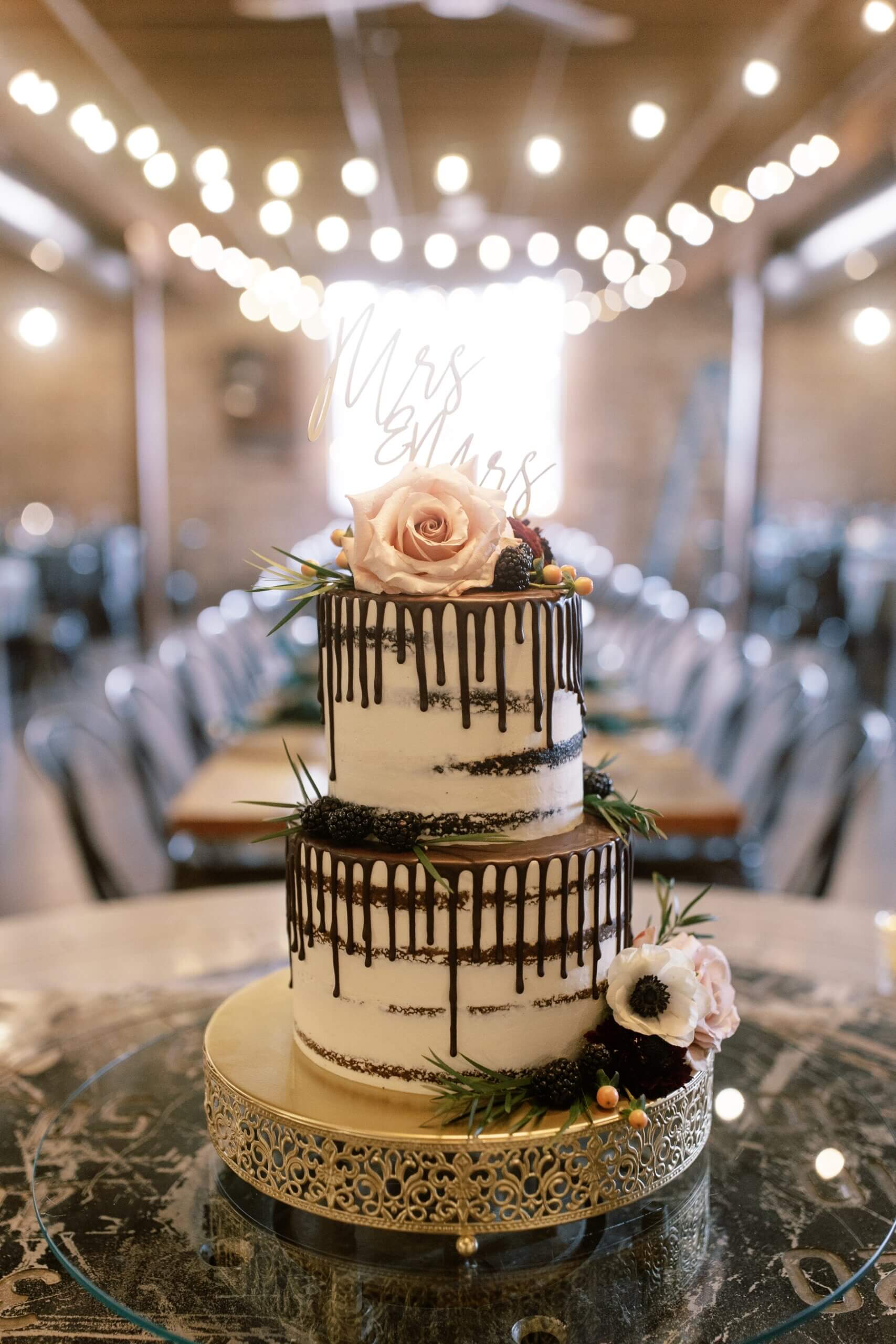 Two tier white wedding cake with black drip icing