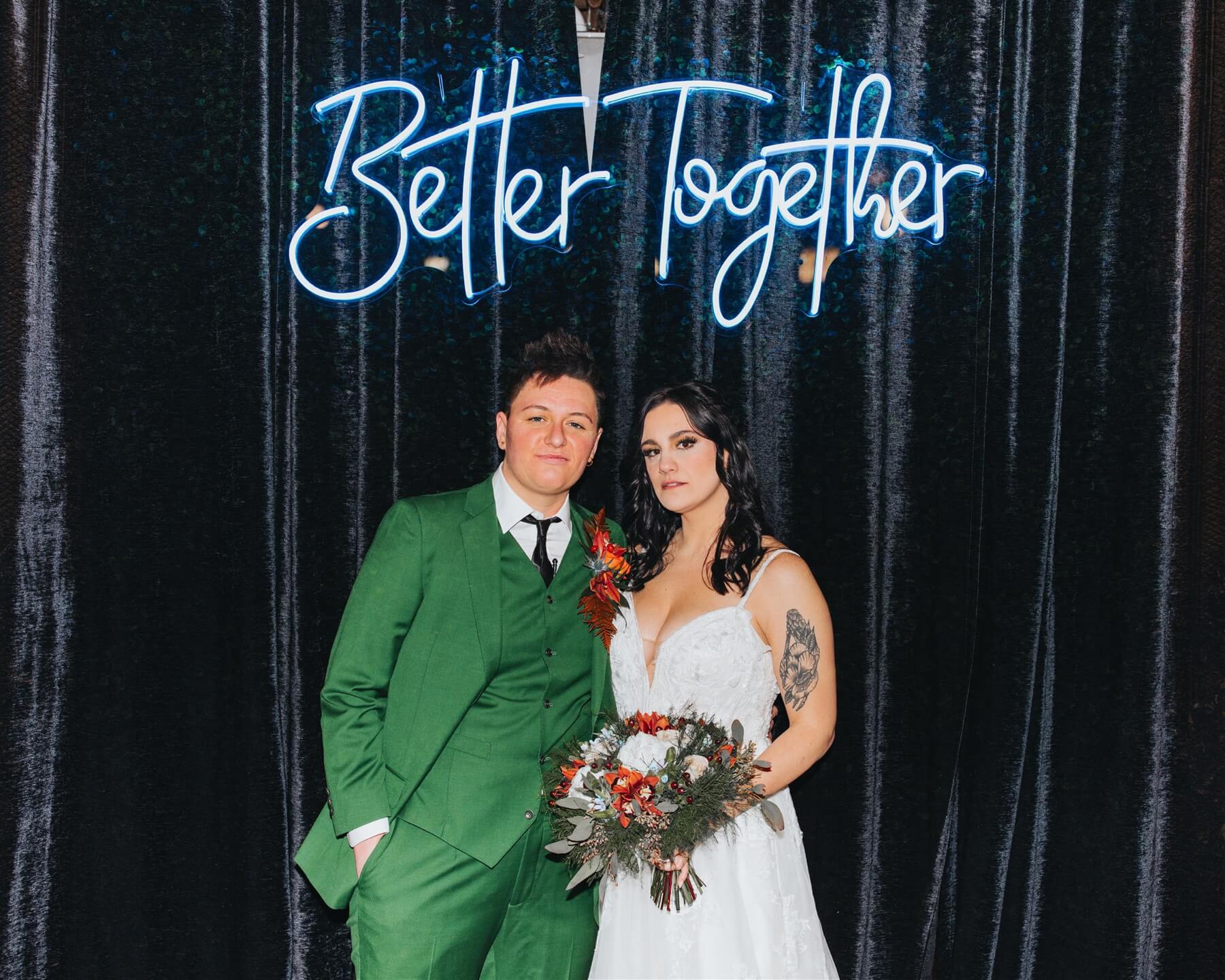 Couple standing under neon better together sign