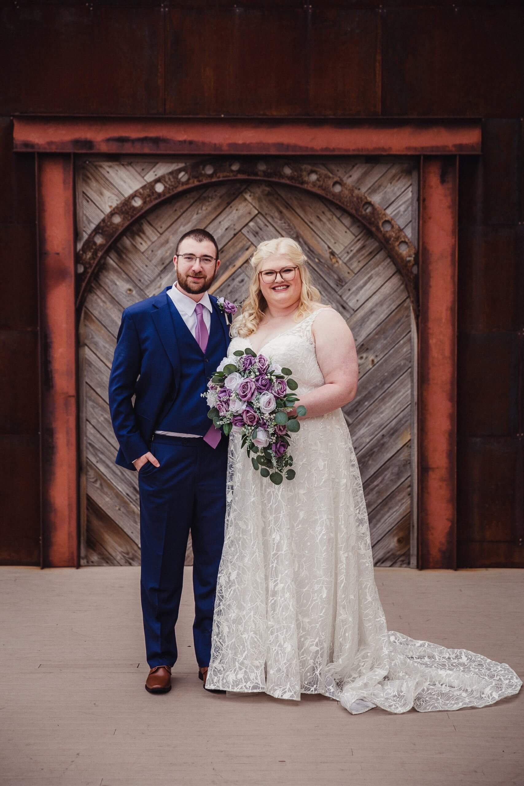 Bride and groom standing in front of wood door on outdoor deck of The Haight