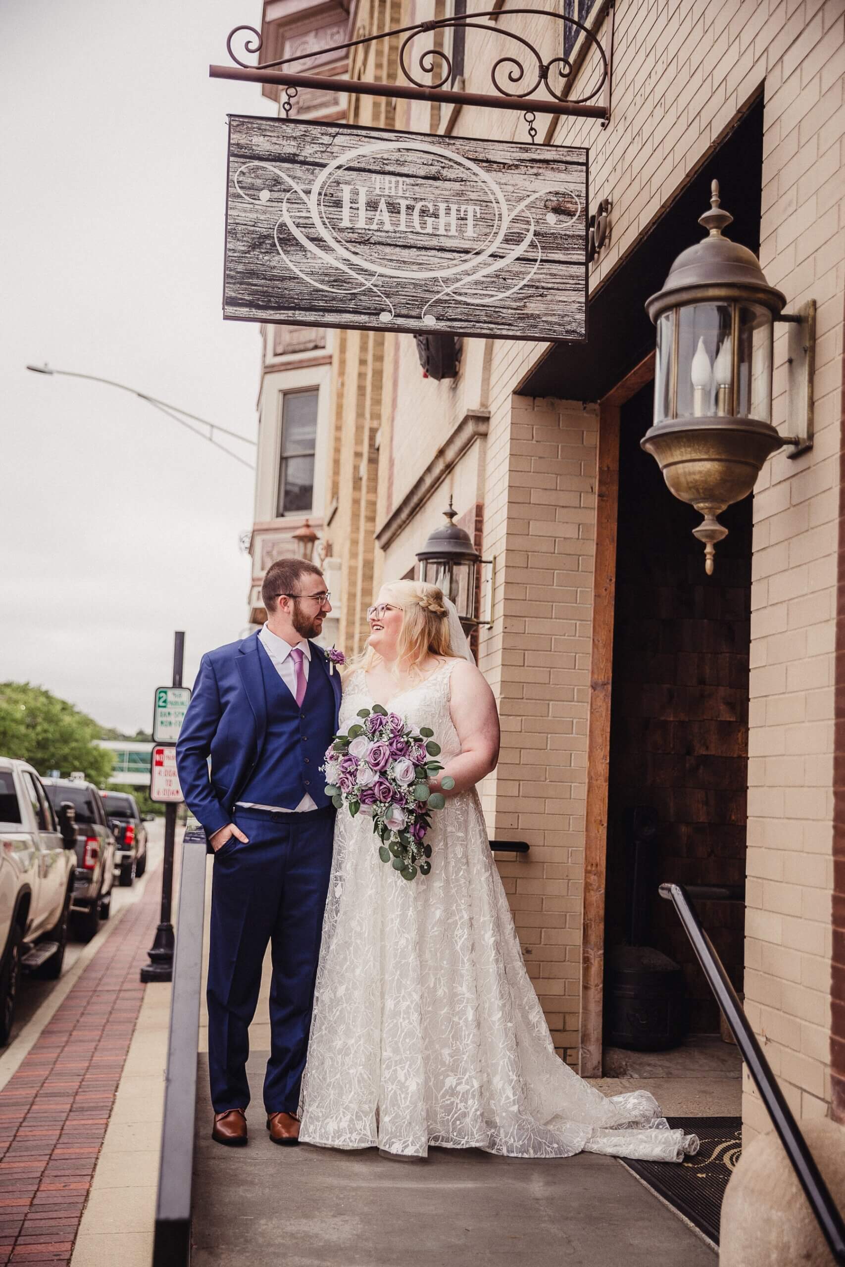 Bride and groom standing under sign at The Haight