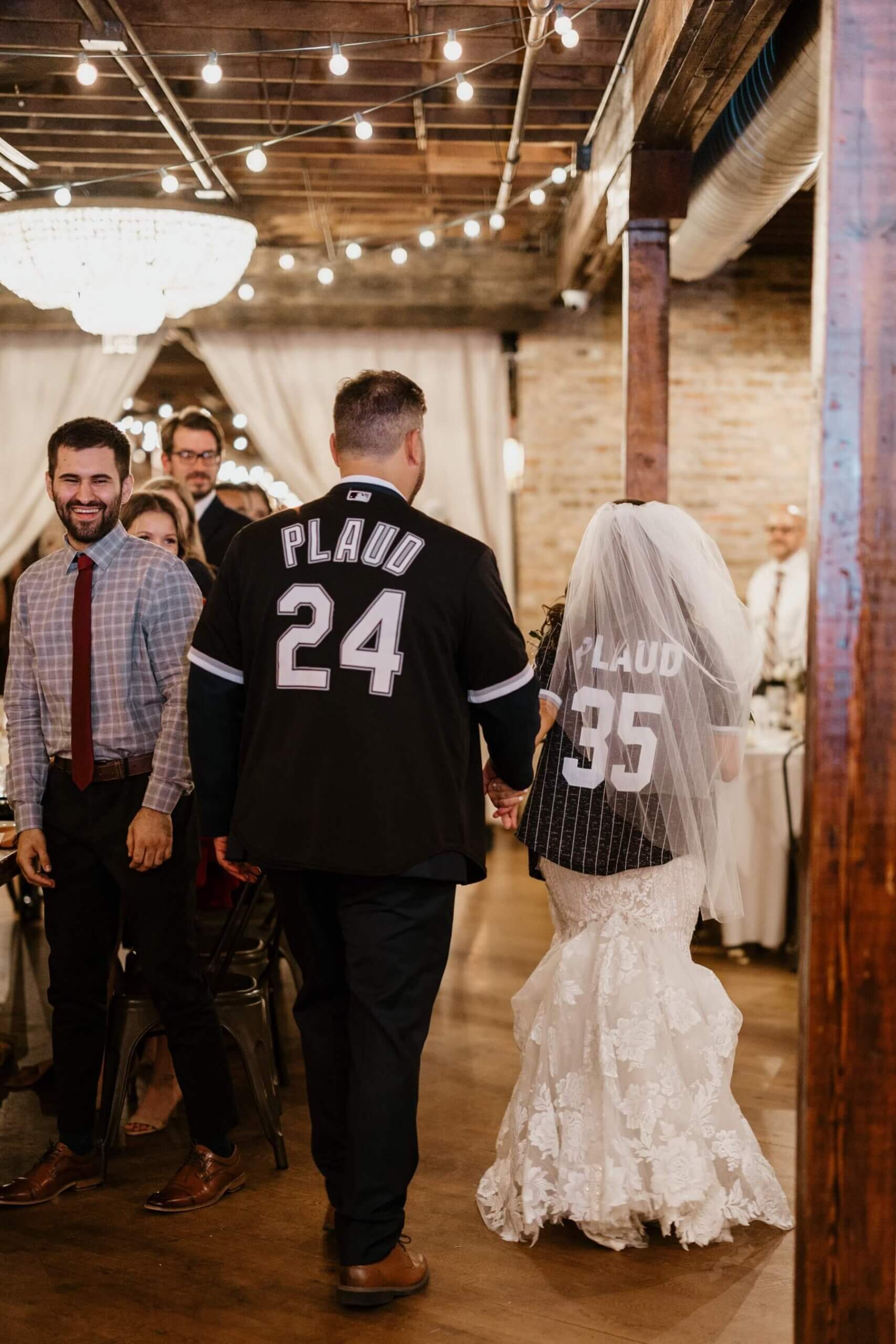 Bride and groom in custom White Sox jerseys entering wedding reception at The Haight