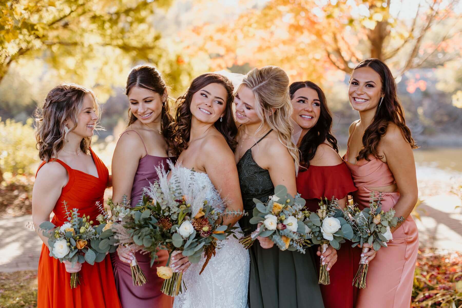 Bride with bridesmaids in mismatching dresses with boho bouquets