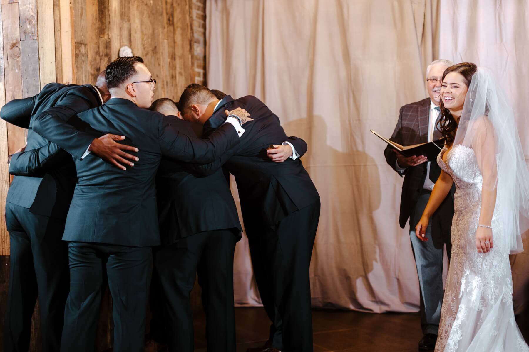 Groom hugging groomsmen during ceremony
