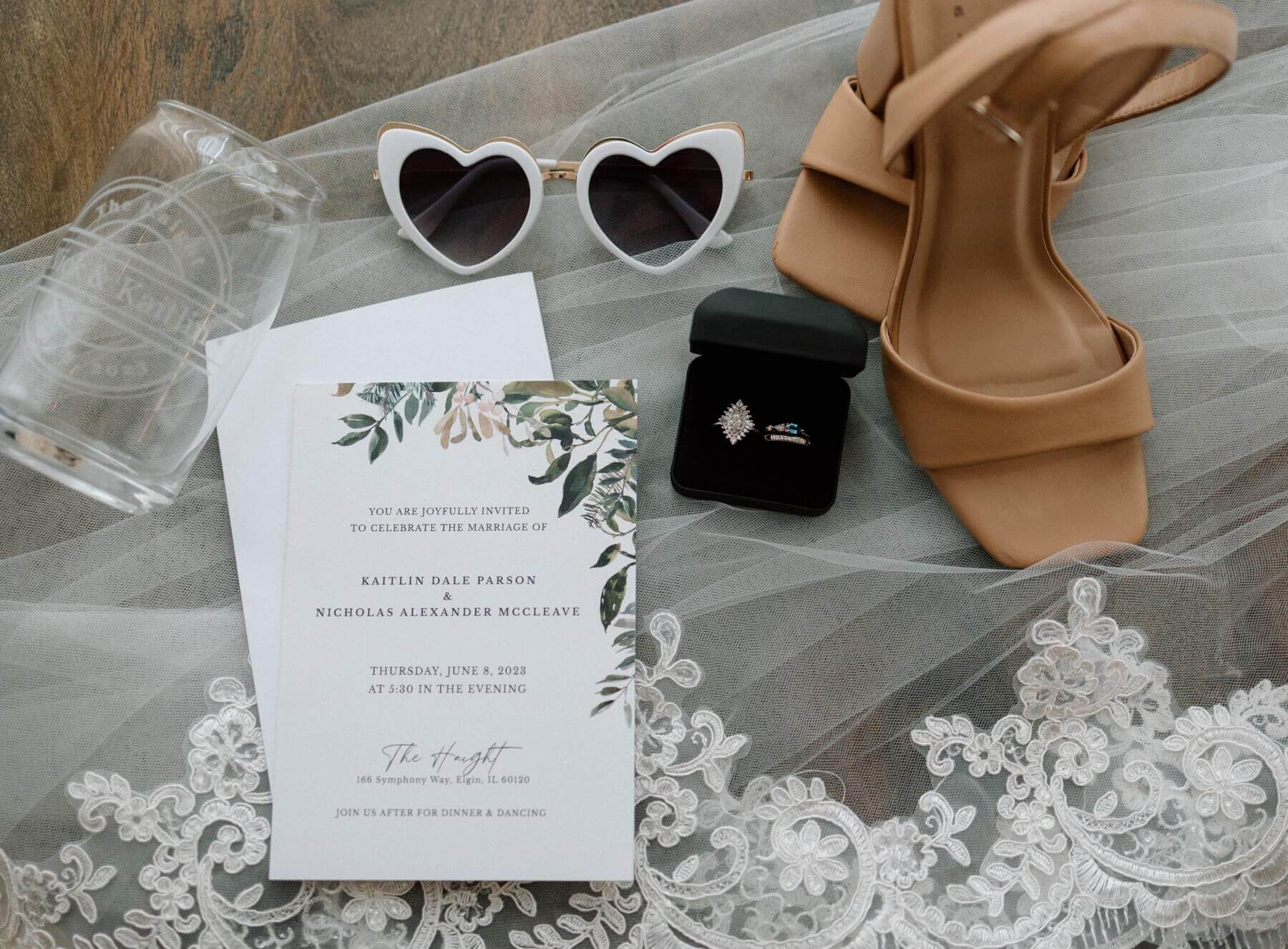 Wedding invitation with rings in ring box and heart sunglasses on veil