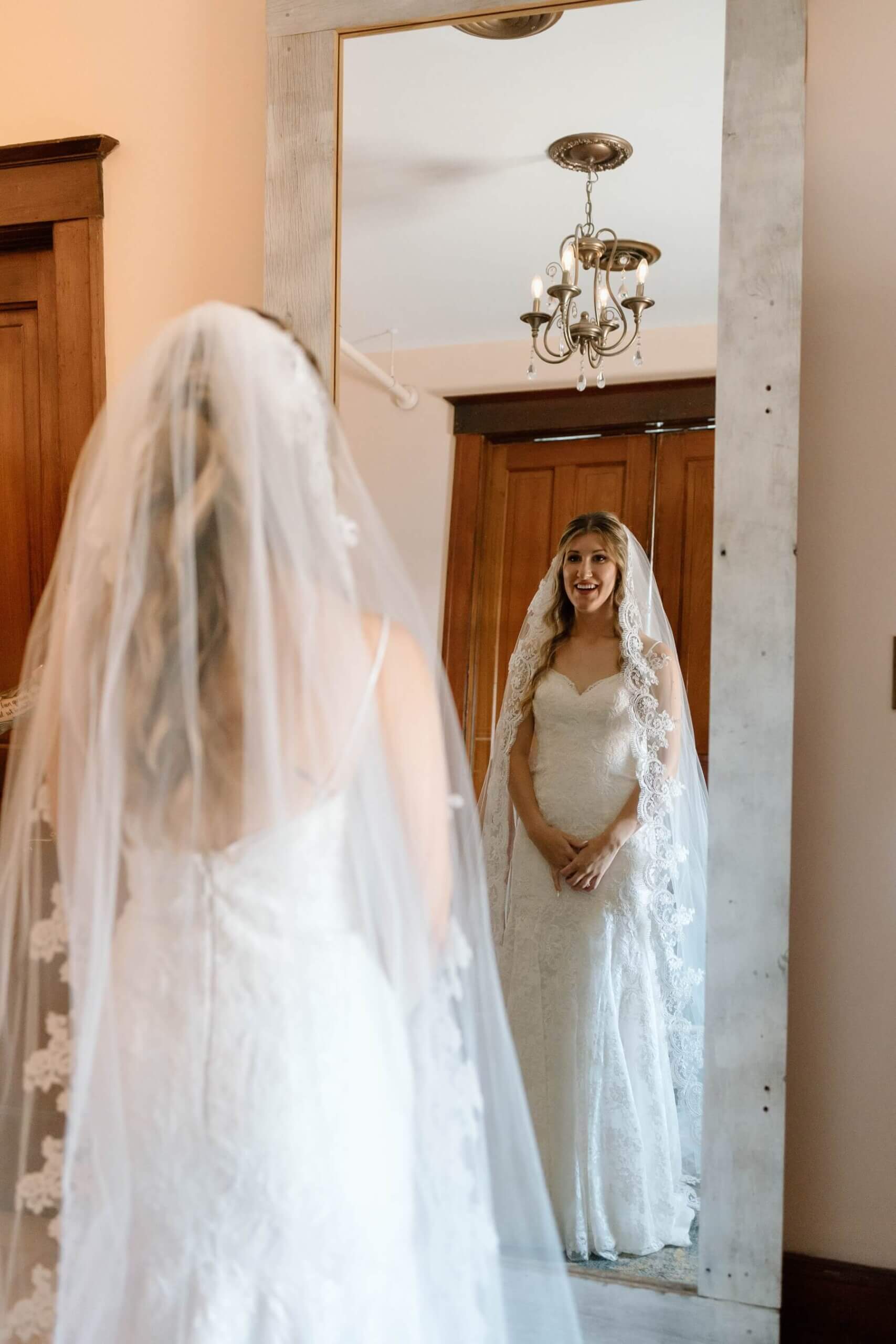 Bride in wedding dress looking in mirror in bridal suite at The Haight