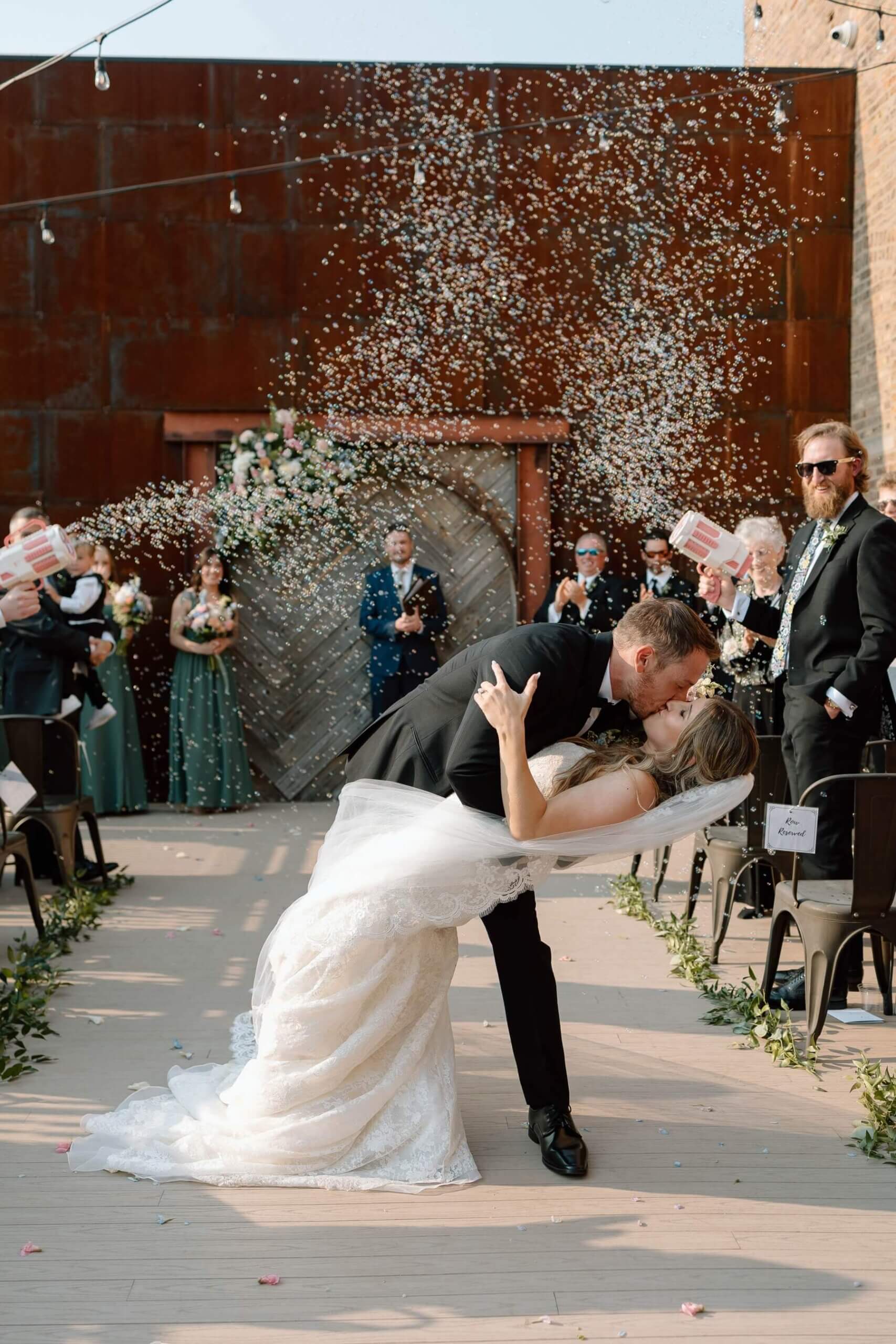 Groom dipping bride for kiss during ceremony exit
